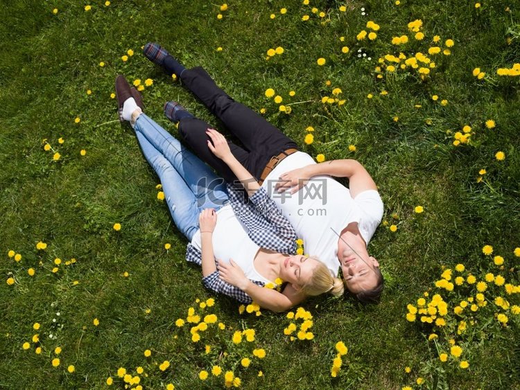 俯瞰躺在草地上的年轻男女，俯瞰