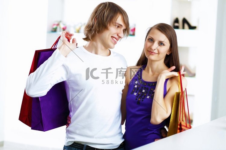 年轻的高加索夫妇背着包一起购物