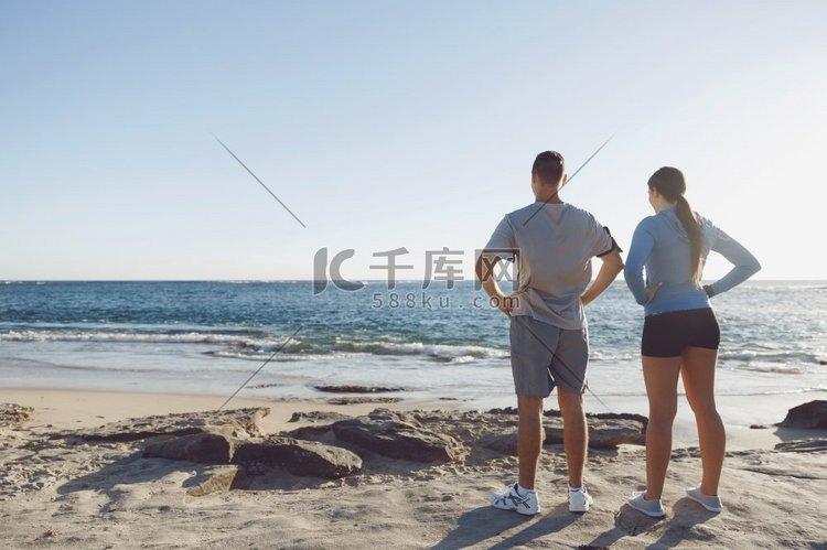 一对年轻夫妇一起在海滩上训练。