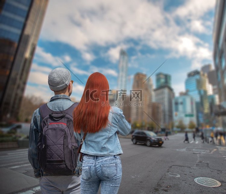 一对年轻夫妇走在曼哈顿的背景下