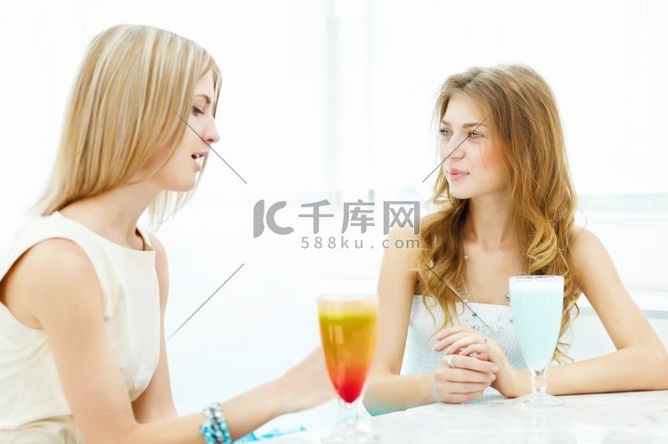 年轻漂亮的女人端着一杯饮料坐在