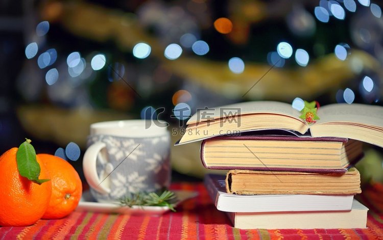 打开的书，杯热饮和橙色水果与假