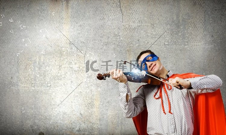超人拉小提琴。穿着超级英雄服装