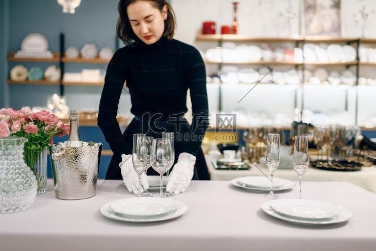 女服务员戴着手套把盘子放在餐桌