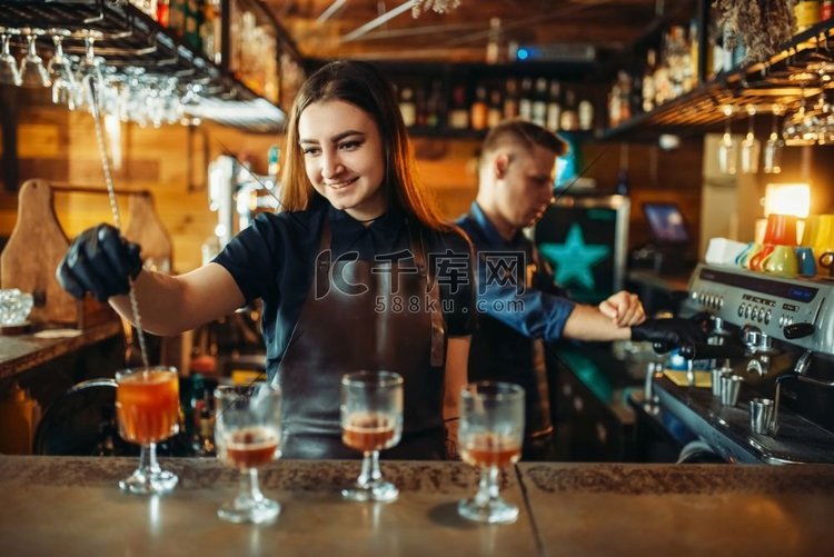 酒吧柜台的男酒保和女酒保。酒精