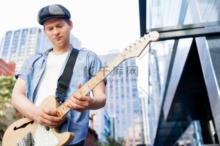 城市里弹吉他的年轻音乐家。城市