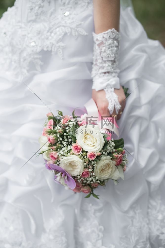 新娘手中的结婚花束，配上玫瑰、