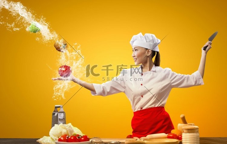 亚裔女厨师用刀做饭。亚洲女厨师