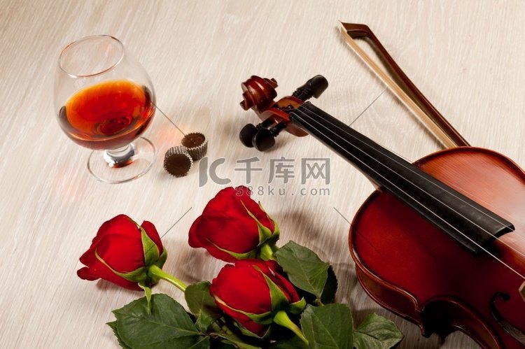 红玫瑰和一把小提琴。桌子上放着