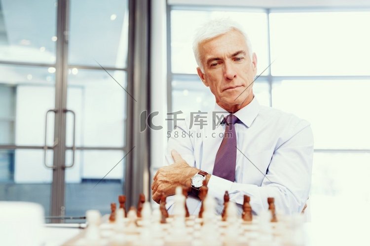 办公室里的生意人在下棋。思考下