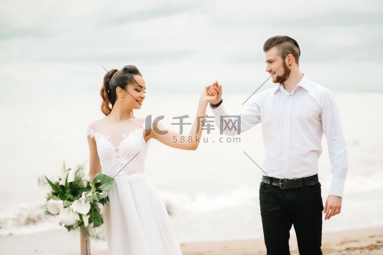 年轻夫妇新郎与新娘在沙滩上在婚
