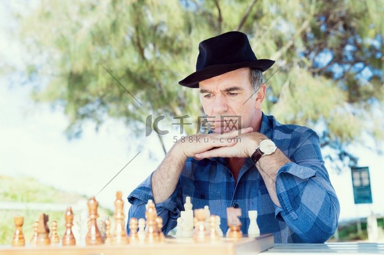 坐在户外下棋的老人。对象棋策略