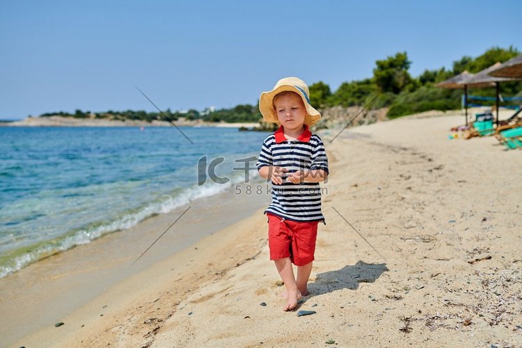 2岁的蹒跚学步的男孩在海滩上 