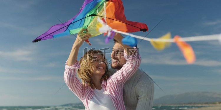 一对情侣在海滩放风筝，在秋天玩
