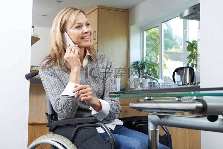坐在轮椅上的残疾妇女在家打手机