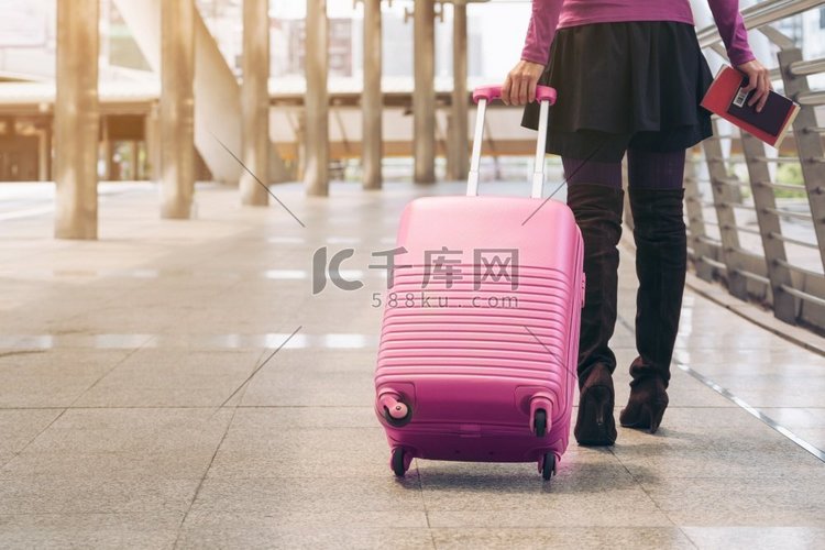 女旅行者携带旅行包或行李在机场