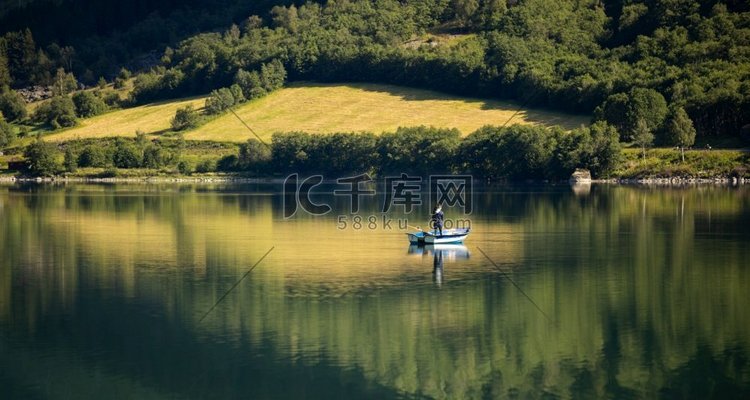 女人在船上钓鱼。美丽的自然挪威