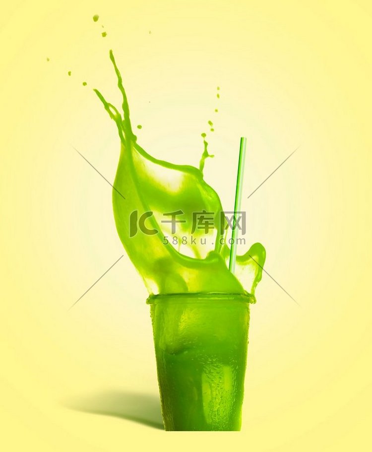带吸管和绿色飞溅夏季饮料的玻璃