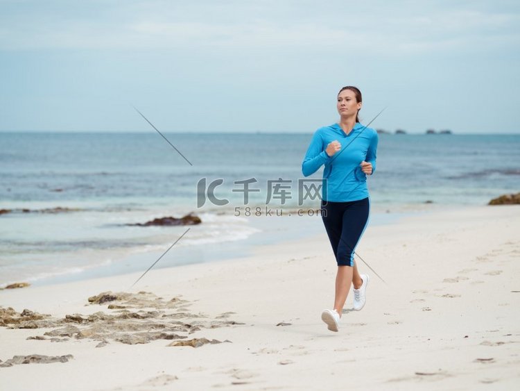 健美的年轻女子在海边奔跑