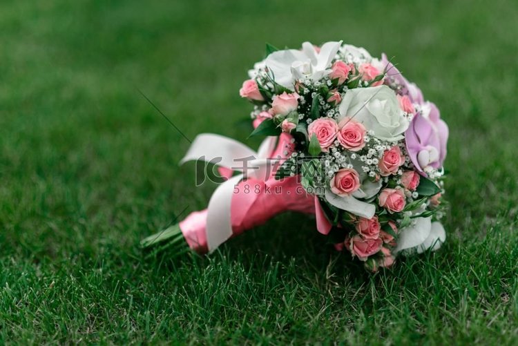 草地上的婚礼花束，有玫瑰、兰花
