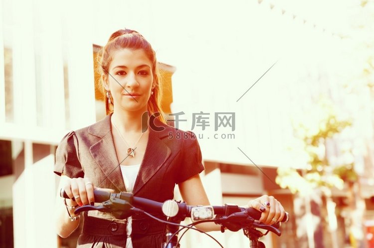 骑自行车上下班的年轻女子。在城