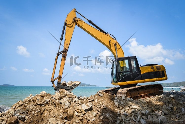 反铲装载机挖掘机石工作在海滩的