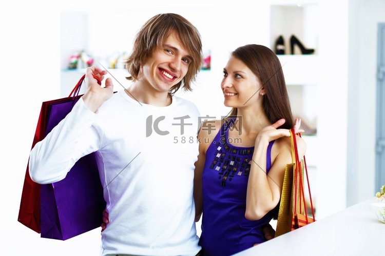 年轻的高加索夫妇背着包一起购物