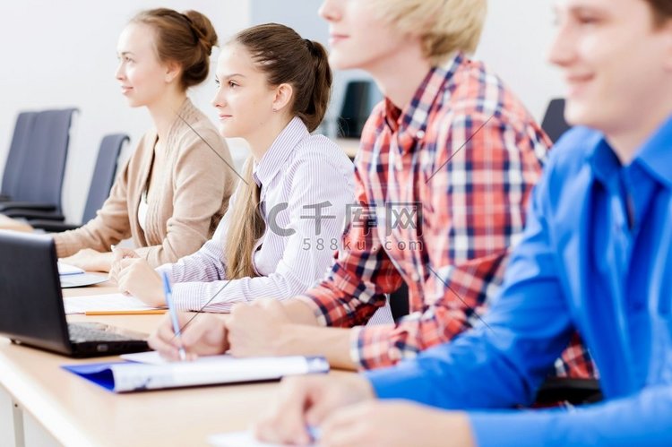 年轻人坐在教室里听讲座。上课的