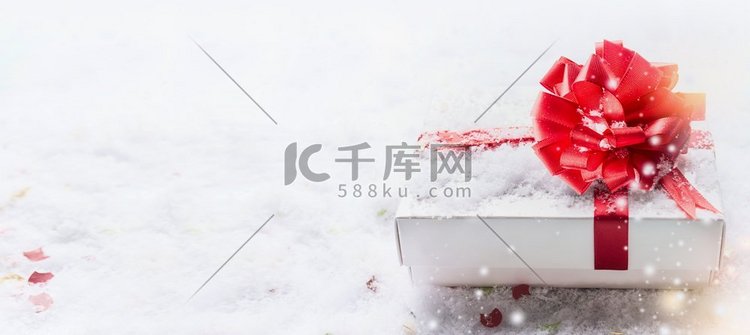 白色礼品盒与红色蝴蝶结在雪与b