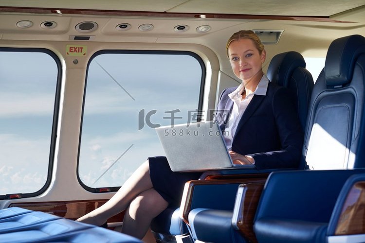 女商人在直升机机舱内用笔记本电