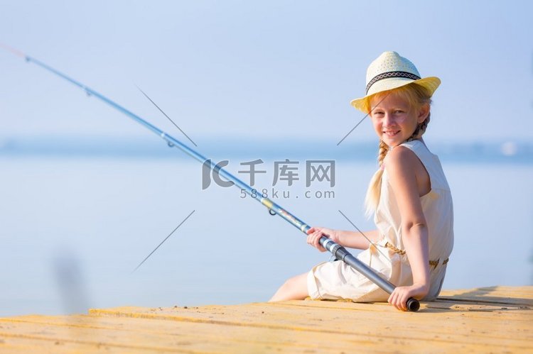 女孩在一件衣服和一顶帽子与钓鱼
