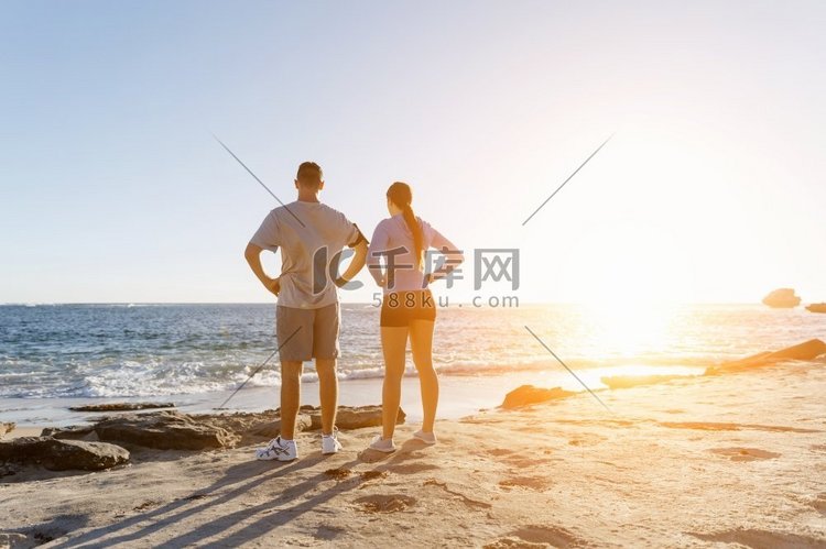 一对年轻夫妇一起在海滩上训练。