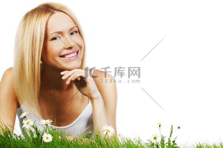 美丽的年轻金发女子躺在草地上开