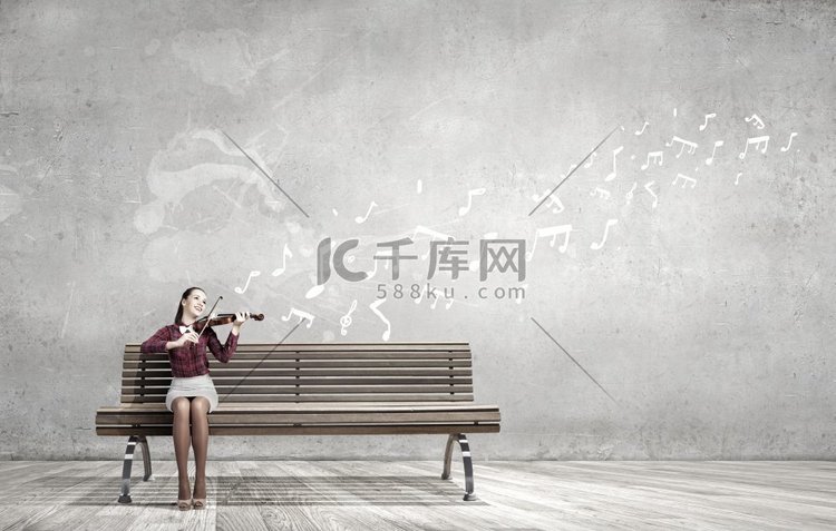 女小提琴家。坐在板凳上拉小提琴