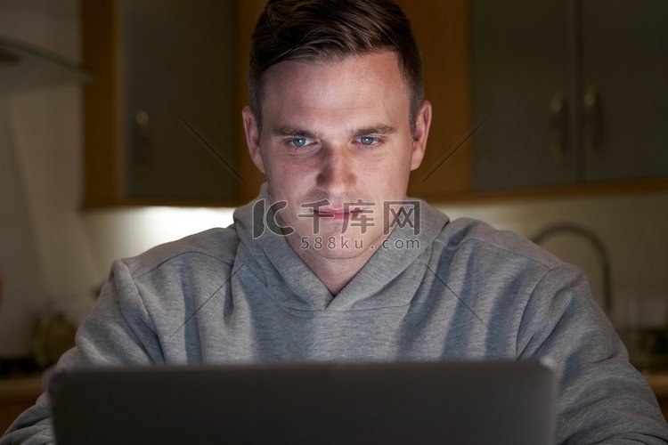 可疑男子晚上在家使用笔记本电脑