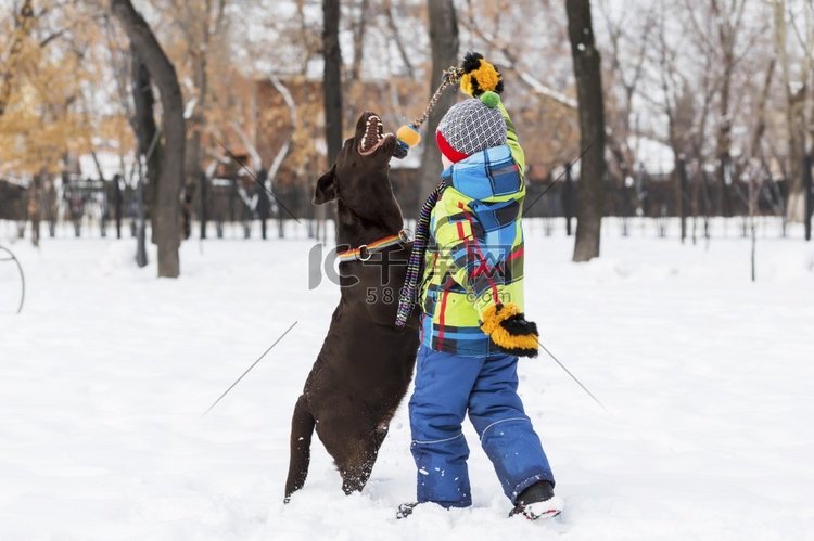 学龄儿童与狗在冬季公园。我和我