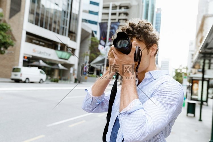 男摄影师在拍照。专业摄影师在城