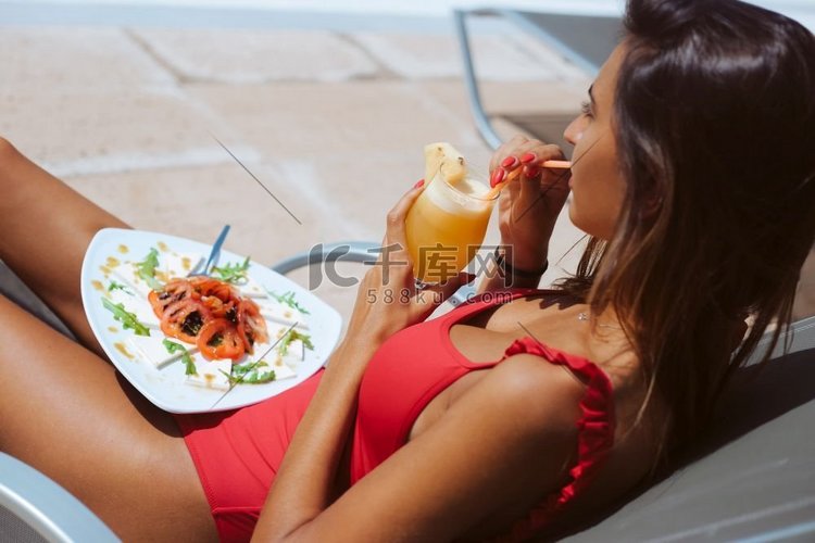 妇女吃新鲜沙拉和喝果汁附近的游