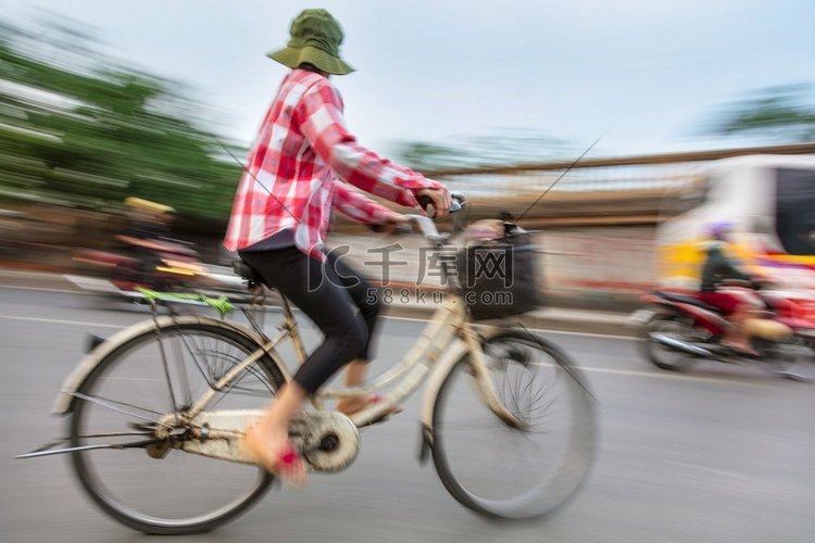 在越南街头骑自行车的越南妇女，