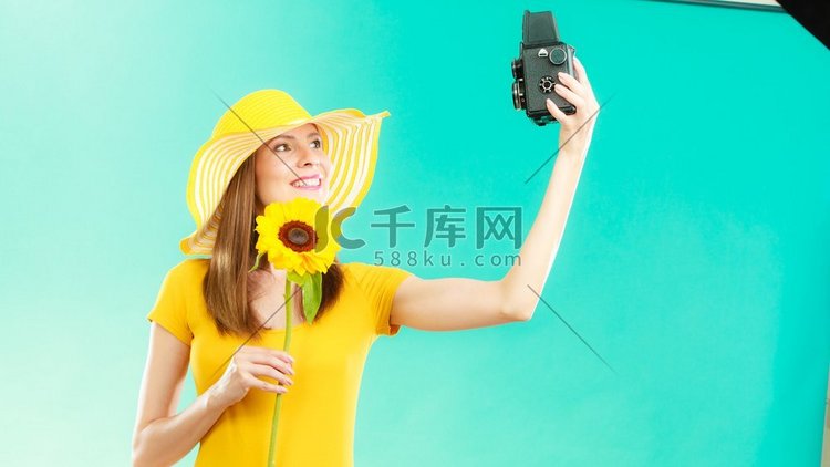 夏天妇女穿黄色衣服和帽子与向日