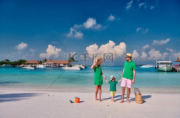 海滩上的一家人，穿着绿色衣服的