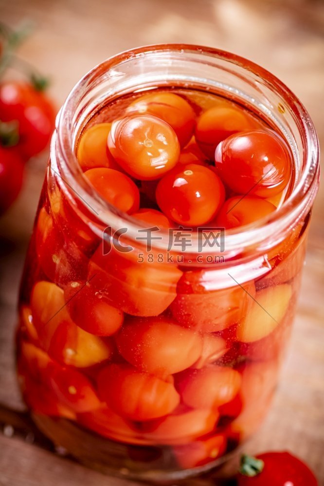 在玻璃罐里腌熟西红柿。在一个木
