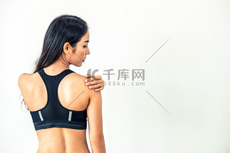 运动妇女触摸肩膀在健身房。健康