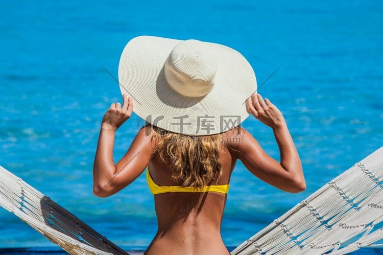 戴着太阳帽的女人在蓝色大海的背