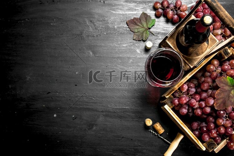 红酒和新鲜葡萄装在盒子里。在黑