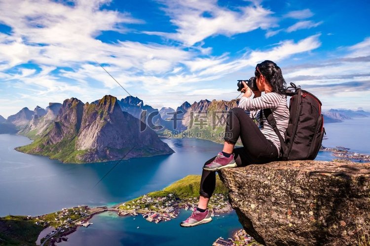 自然摄影师游客站在山顶上用相机