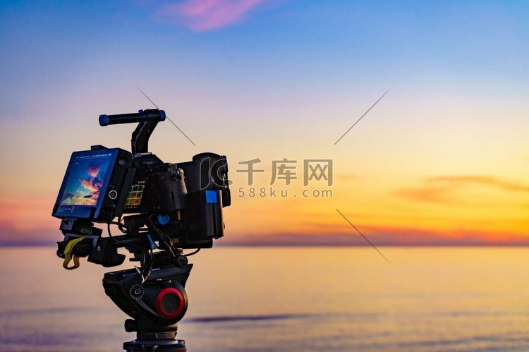 用三脚架拍摄海上日落的专业相机