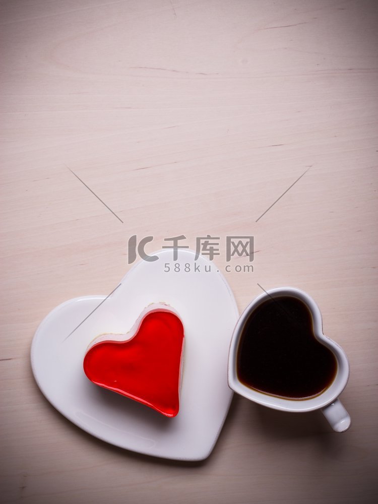 木质表面的心形咖啡杯和果冻蛋糕