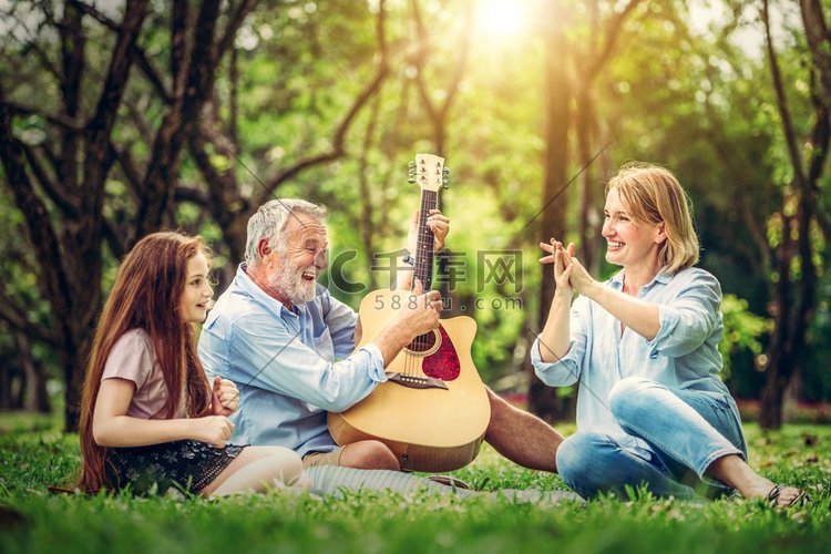 夏天，快乐的一家人坐在公园里弹