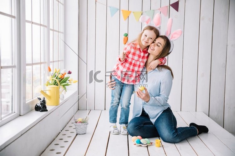 小女孩妈妈兔子耳朵坐在复活节彩